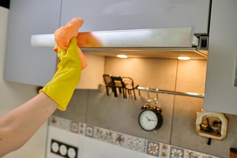 a person cleaning their kitchen cabinets